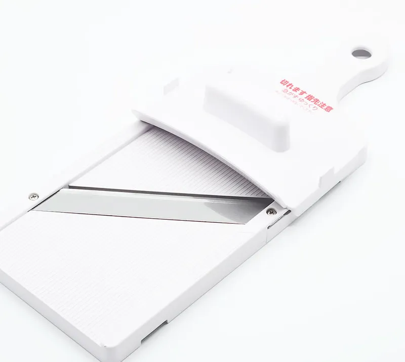Shimomura handheld mandoline slicer with a stainless blade and white body