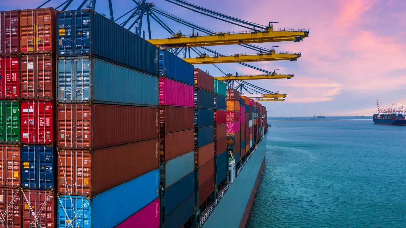 Container ship loading at a port at dusk